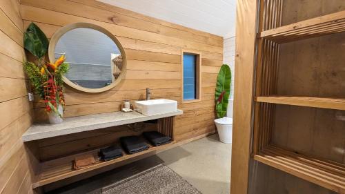 a bathroom with a sink and a mirror at Bombua Beach House in Luganville