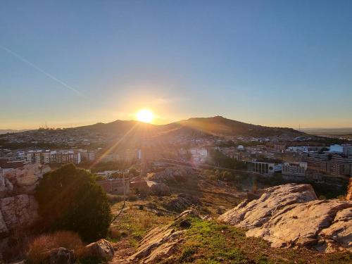 a view of the sun setting over a city at Casa Oasis Puertollano, una casa rural en Puertollano, agradable, con Piscina en zona tranquila in Puertollano