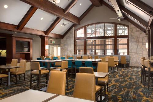 a dining room with tables and chairs at Residence Inn Kansas City Airport in Kansas City