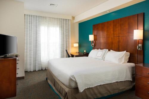 a hotel room with a large bed and a television at Residence Inn Kansas City Airport in Kansas City