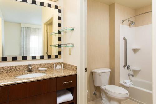 a bathroom with a sink and a toilet and a mirror at Residence Inn Kansas City Airport in Kansas City