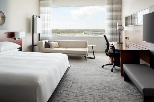a hotel room with a bed and a desk at Marriott Montreal Airport In-Terminal Hotel in Dorval