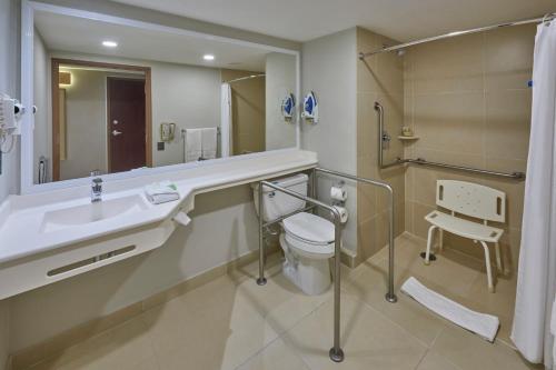 a bathroom with a sink and a toilet and a mirror at City Express by Marriott Los Mochis in Los Mochis