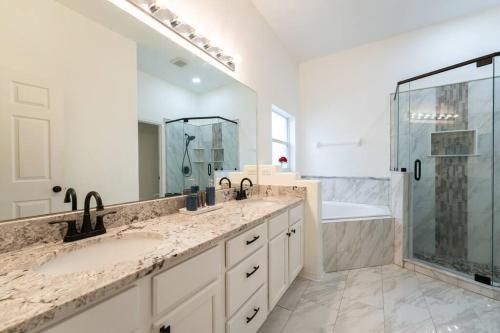 a bathroom with two sinks and a shower at The Dream Vacation Home! in Orlando