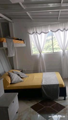 um quarto com uma cama e uma janela em Mirador del fuerte em São Rafael