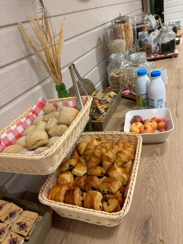 three baskets of pastries and apples on a table at Hotel Le Gambetta in Bergerac