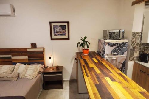 1 dormitorio con 1 cama y un banco de madera. en Mono Estrella - una cuadra de Plaza Independencia en San Miguel de Tucumán