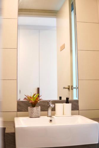 a white sink in a bathroom with a mirror at Serini Gateway Melawati in Kuala Lumpur