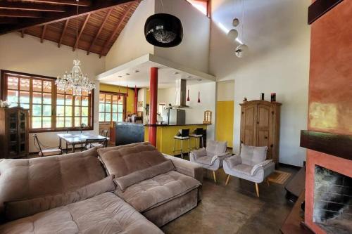 a living room with a couch and a dining room at Charmosa Casa no Lago in Ribeirão Preto