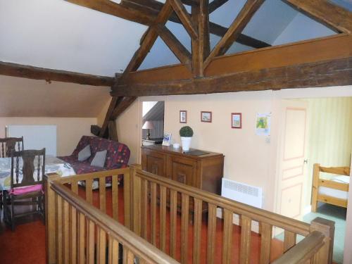 un salon avec un escalier en bois et une chambre avec une table dans l'établissement Gîte paisible avec 2 chambres et cour, au-dessus de la mairie, près de Langres - FR-1-611-22, à Perrancey