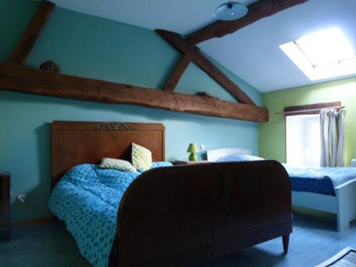 Schlafzimmer mit einem Bett mit einem Kopfteil aus Holz in der Unterkunft Gîte Breuvannes-en-Bassigny, 3 pièces, 5 personnes - FR-1-611-44 in Breuvannes