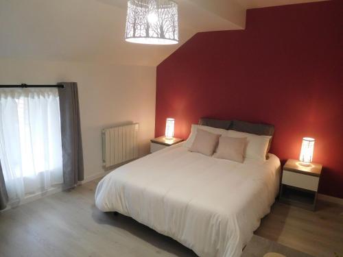ein Schlafzimmer mit einem weißen Bett und einer roten Wand in der Unterkunft Gîte Gilley, 3 pièces, 4 personnes - FR-1-611-71 