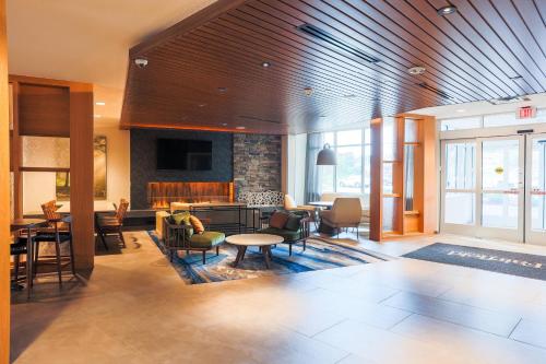 a lobby with chairs and tables and a living room at Fairfield Inn & Suites Marquette in Marquette