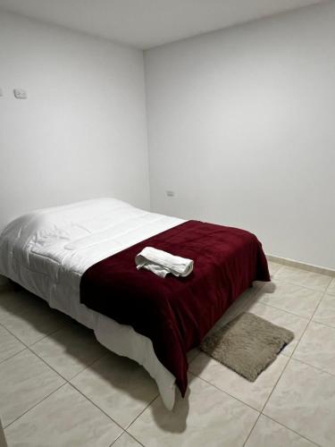 1 dormitorio con 1 cama con manta roja y alfombra en Apartamento pitalito, en Pitalito
