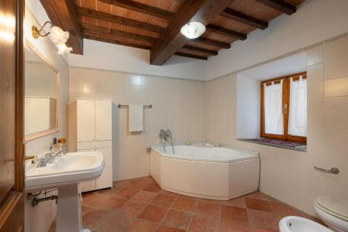 een badkamer met een bad, een wastafel en een toilet bij Baco in Ampinana