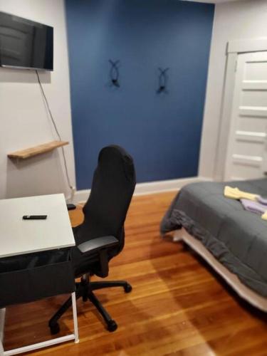 a bedroom with a desk and a bed and a chair at downtown and secluded in Manchester