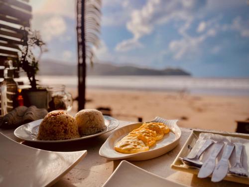 two plates of food on a table near the beach at Amwani Beach Camp in El Nido