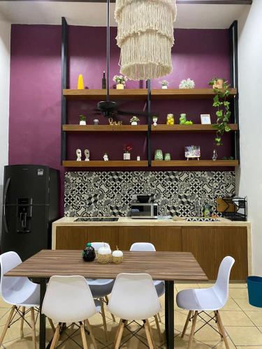 a dining room with a table and white chairs at Departamento catalina in Mérida