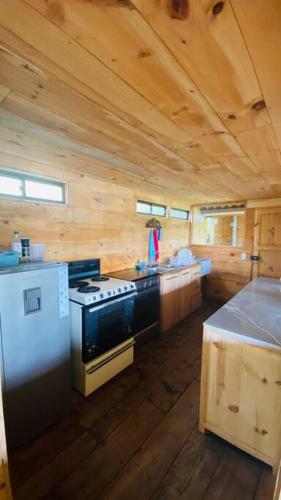 a kitchen with a stove and a sink in a cabin at Cabaña en La Laguna de la Cocha in Pasto
