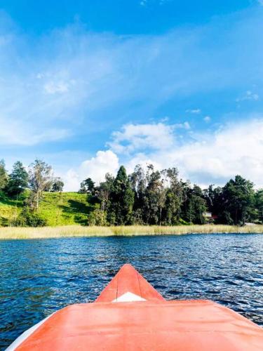 a red boat in the water on a lake at Cabaña en La Laguna de la Cocha in Pasto