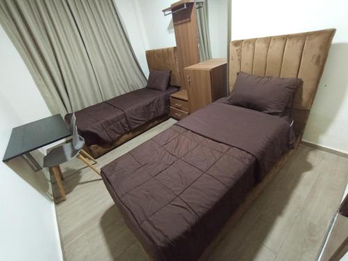 Un pat sau paturi într-o cameră la Hôtel Meuble Parisien