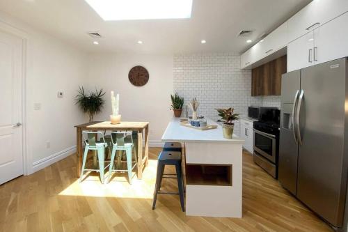 a kitchen with a refrigerator and a counter with stools at Cozy Bedroom - Shared Kitchen & Living room - Brooklyn Townhouse - 25min Manhattan in Brooklyn