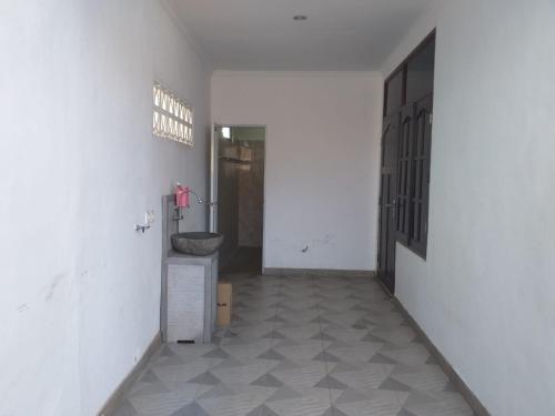 a hallway with a sink in a white room at Juicezzy Home in Panji