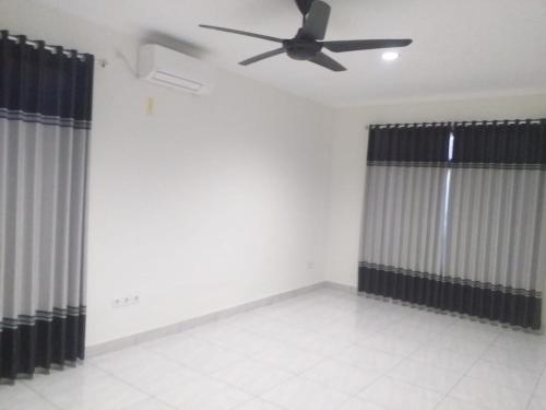 a room with black and white curtains and a ceiling fan at Juicezzy Home in Panji