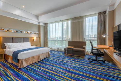 a hotel room with a bed and a desk and a tv at Holiday Inn Express Tianjin Heping, an IHG Hotel in Tianjin