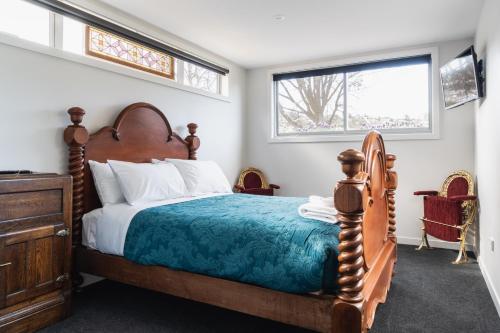 1 dormitorio con cama de madera y ventana en Lavender Box en Dunedin