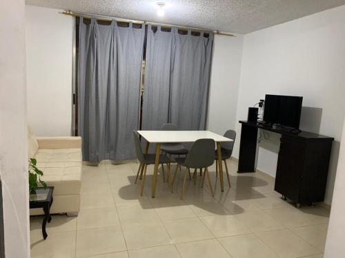 a dining room with a table and chairs and a television at Apto de 3 habitaciones con ventilador y parqueadero comunal in Valledupar