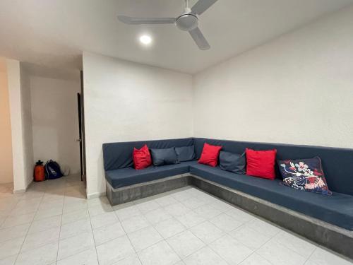 a blue couch in a room with red pillows at Casa y departamentos lavanda in Mérida