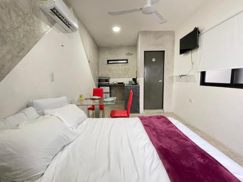 a bedroom with a large bed and a table at Casa y departamentos lavanda in Mérida