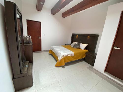 - une chambre avec un lit et une couverture jaune dans l'établissement Los Arcos Hottel Boutique, à Morelia