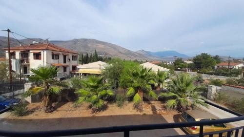 - un balcon offrant une vue sur une maison avec des palmiers dans l'établissement Delphi View!, à Galaxidi
