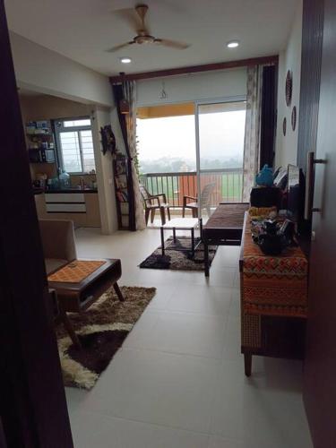 a living room with a couch and a table at Cozy Home near Bhavali Dam in Igatpuri