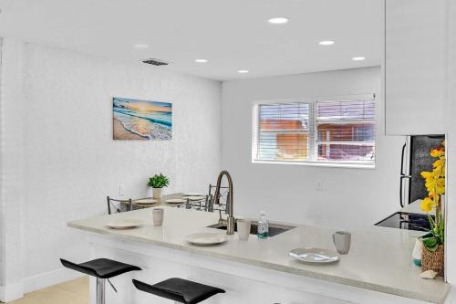 a white kitchen with a counter and a sink at New Stylish 2 Bdrm Mins To Beach & Aventura Mall in Hallandale Beach