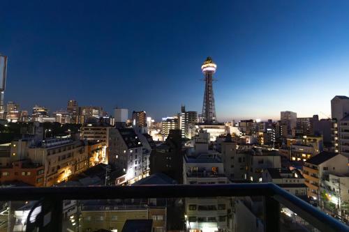 a view of a city at night with a tower at Ocean Tsutenkaku in Osaka