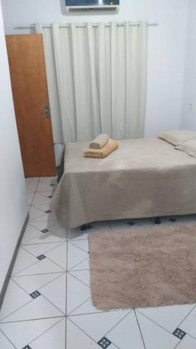 1 dormitorio con 1 cama y suelo de baldosa blanca en Doce Lar - 1 suíte, en Tangará da Serra