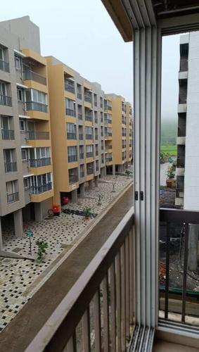 a balcony with a view of some apartment buildings at Cozy Studio near Bhavali Dam in Igatpuri
