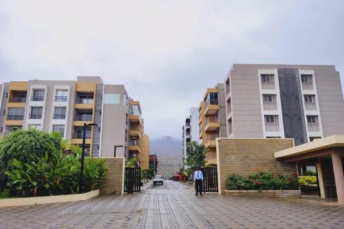a city street with tall buildings and a person standing in the street at Cozy Studio near Bhavali Dam in Igatpuri