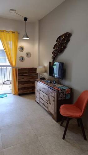 a living room with a chair and a television at Cozy Studio near Bhavali Dam in Igatpuri