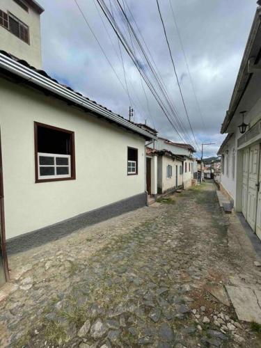 Casa em Ouro Preto في أورو بريتو: زقاق مع مبنى أبيض وخطوط كهرباء
