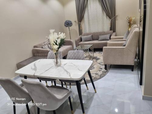 ein Wohnzimmer mit einem weißen Tisch und Stühlen in der Unterkunft أجنحة فندقية مفروشة عوائل فقط in Bisha
