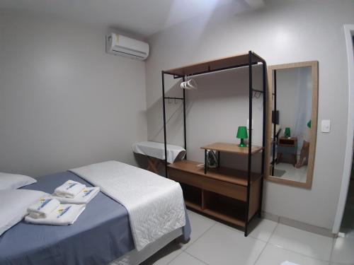 een slaapkamer met een bed, een spiegel en een wastafel bij Casa com piscina Balneário Camboriú CasaAlbertiBc in Balneário Camboriú