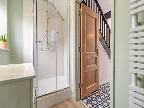 a bathroom with a shower and a glass door at Coconut Mill in Lavenham