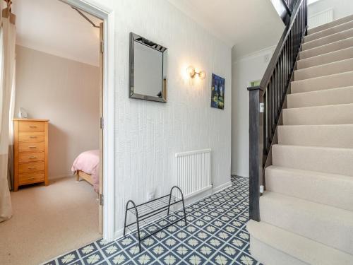 a hallway with stairs and a mirror on the wall at Coconut Mill in Lavenham