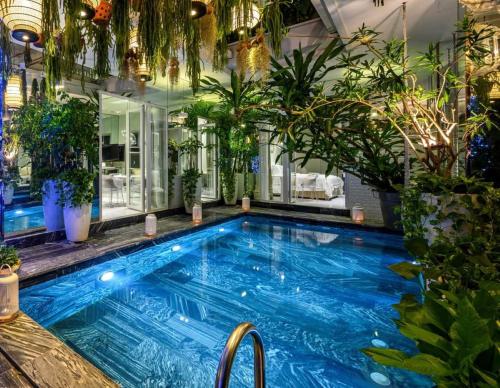 una gran piscina con un montón de plantas en Bed In Town Saigon, en Ho Chi Minh