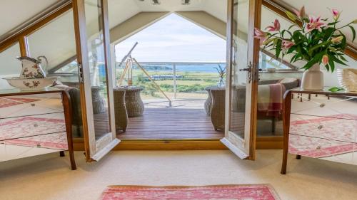 een kamer met een deur naar een balkon bij Tir a Mor in Nefyn