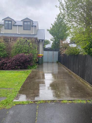 a driveway in front of a house with a fence at Dinsdale oasis and private spa pool in Hamilton